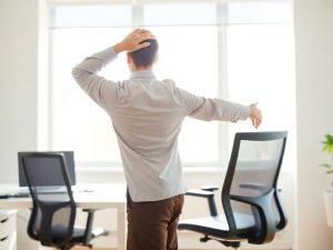 UrbanFitness 15 O persoană în ținută office făcând exerciții la birou.